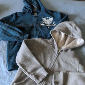 Two boys zip up hoodies